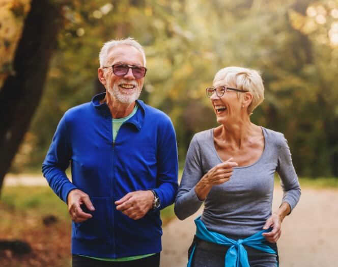 two older adults running outdoors