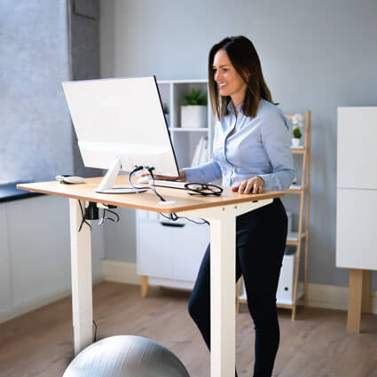 woman using standing desk to work