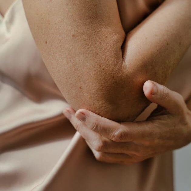 Woman holding her elbow