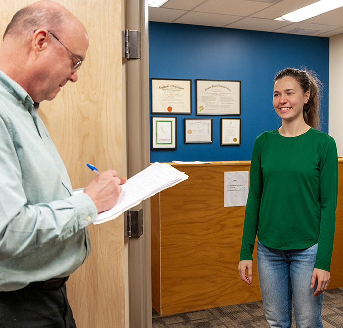 Dr. Gleeson writing on paperwork with patient