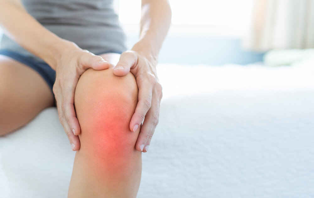 A person with arthritis massaging inflamed knee