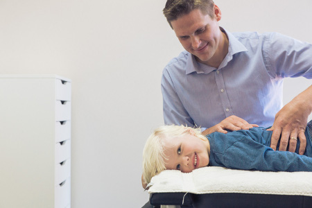 Dr Luke Doing Chiropractic Care to Child