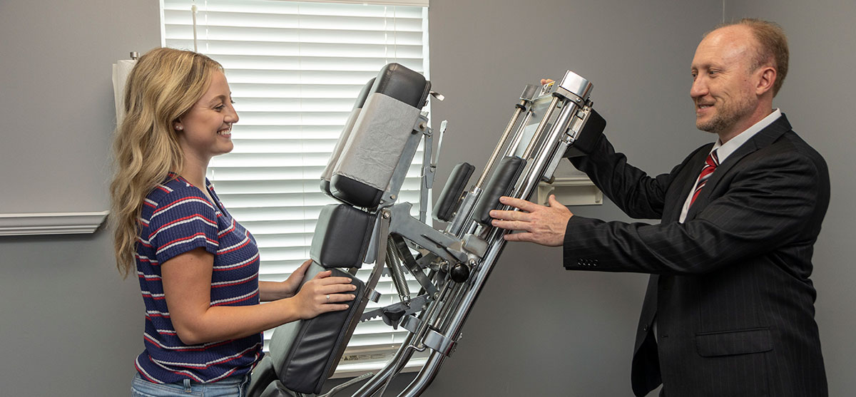 Dr. Paul talking to patient by adjusting table