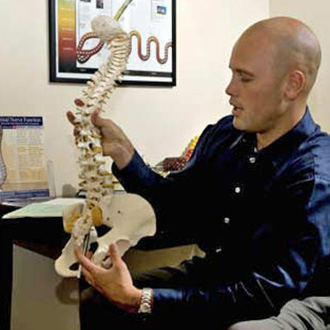 Dr Tim with a model of a spine