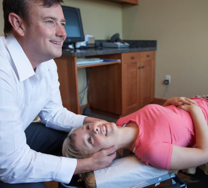 Prineville chiropractor Dr. Hanes adjusting female patient's neck