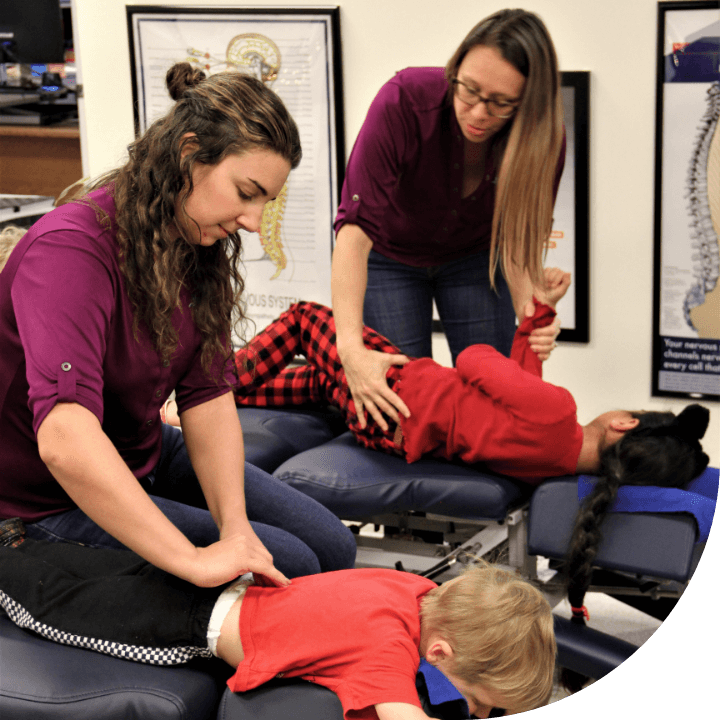 our chiropractors adjusting kids