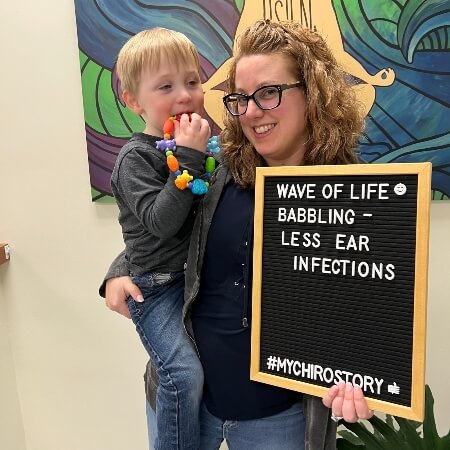Woman holding a young child and a sign
