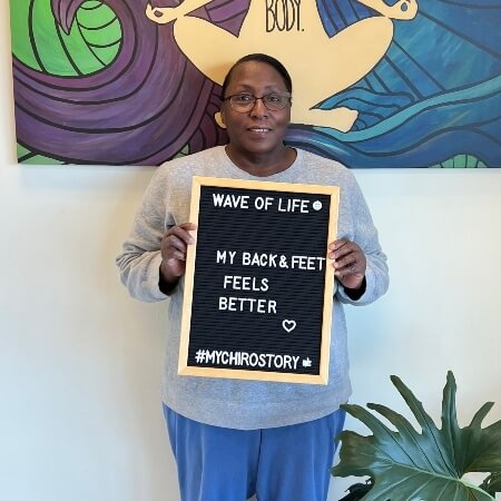 Woman with eyeglasses holding a sign