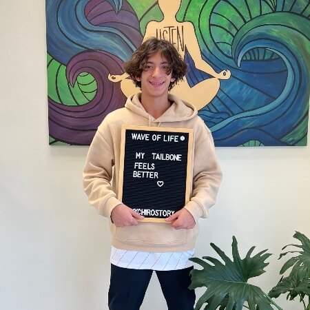 teen holding a black sign