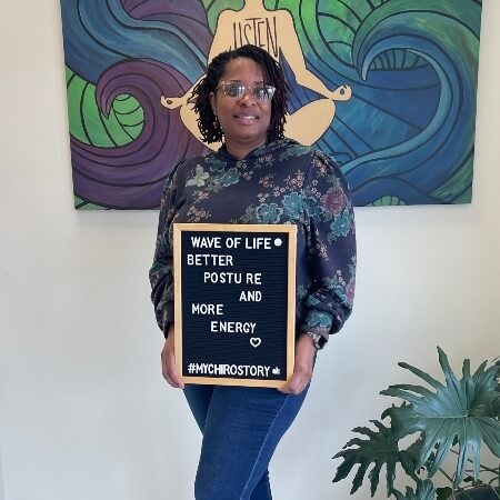 Woman wearing jeans holding a sign
