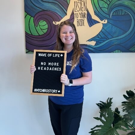 Woman wearing a blue t-shirt holding a sign