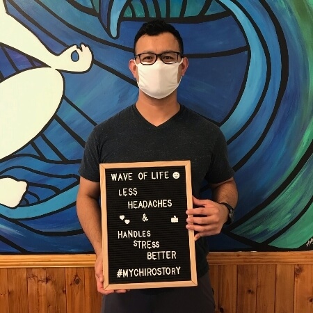 Man wearing facemask holding a sign