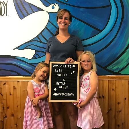 Woman and two young girls holding a sign