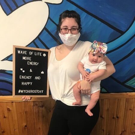 Woman holding a baby and a sign