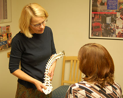 Dr. Helen showing spine model to patient