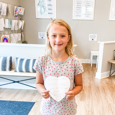 little girl holding paper heart