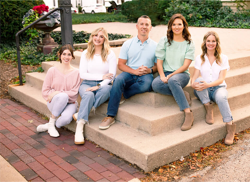 Dr. David Hanson sitting on steps with his family