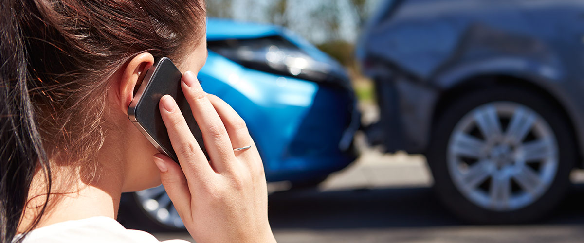 person on phone after auto accident