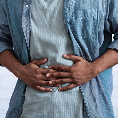 man-standing-with-stomach-pain-sq