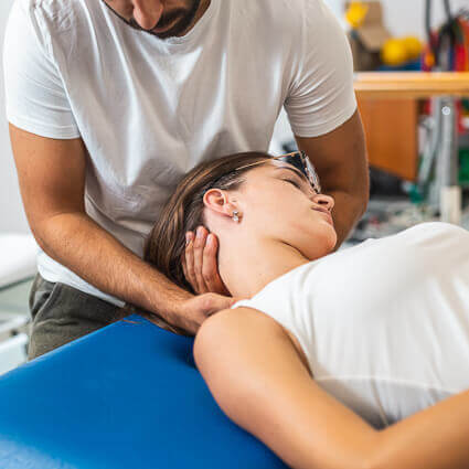 woman laying on blue table having neck adjusted