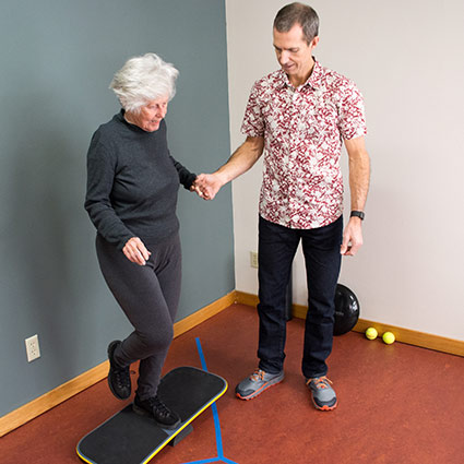Dr Noble with a patient working on the balance board