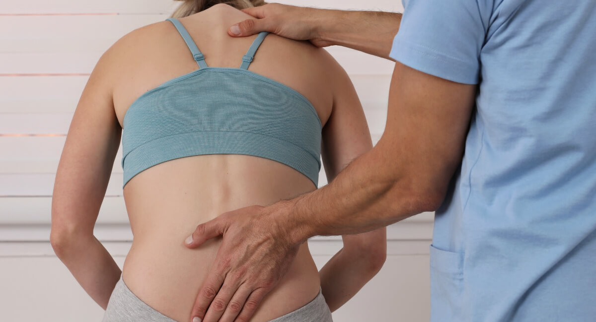 Chiropractor inspecting patient's back