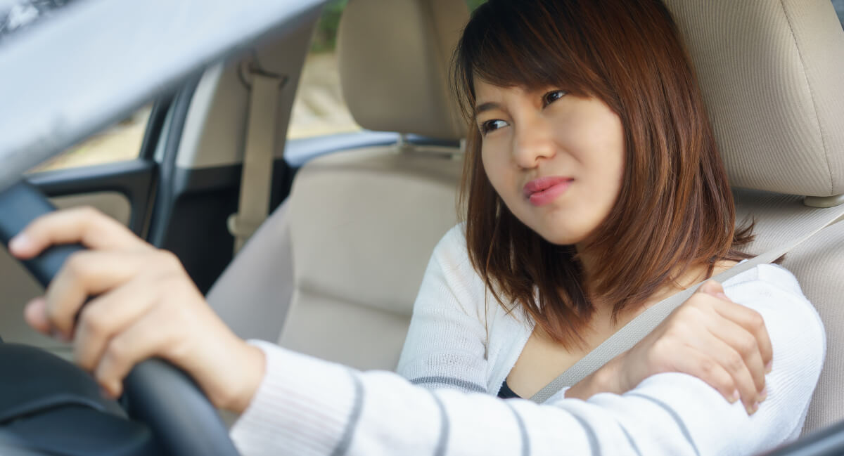Woman sitting in car with shoulder pain
