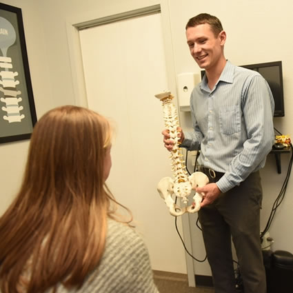 Dr. Carroll holding spine model