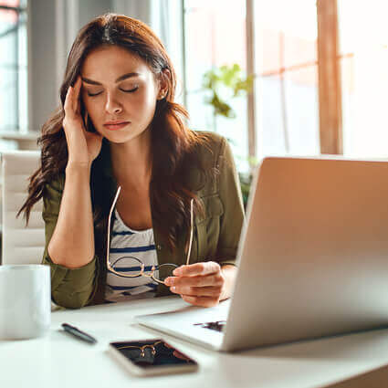 woman holding at glasses with headache