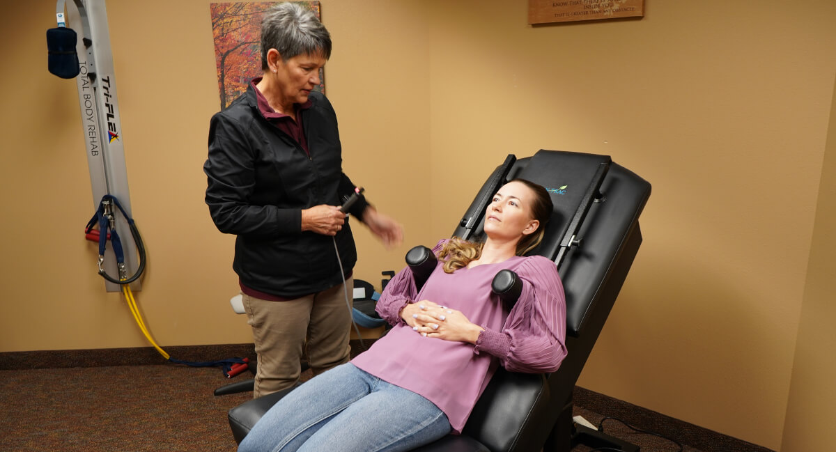 Staff member assisting patient with Spinal Decompression Therapy