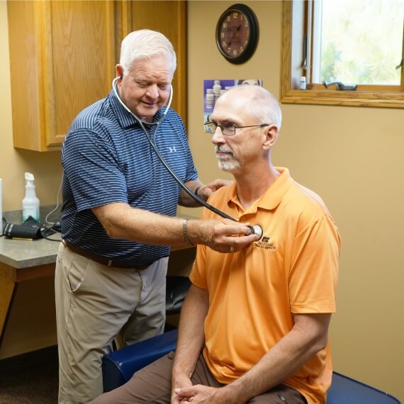 Marshall chiropractor Dr. David Hoganson checking patient's heartrate