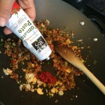 Adding tomato paste to the mixture of meat and vegetables