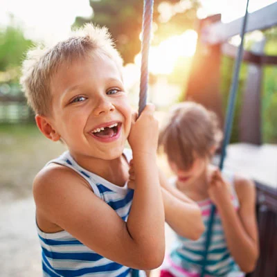 A boy swinging in a park after his ear infection treatment in Boston, MA