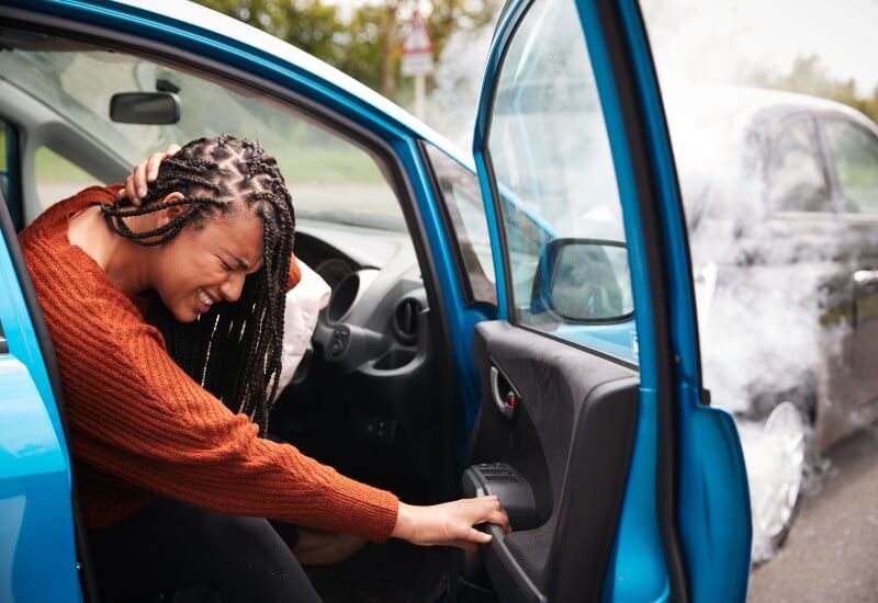 A woman in a car suffering from Neck pain in Boston