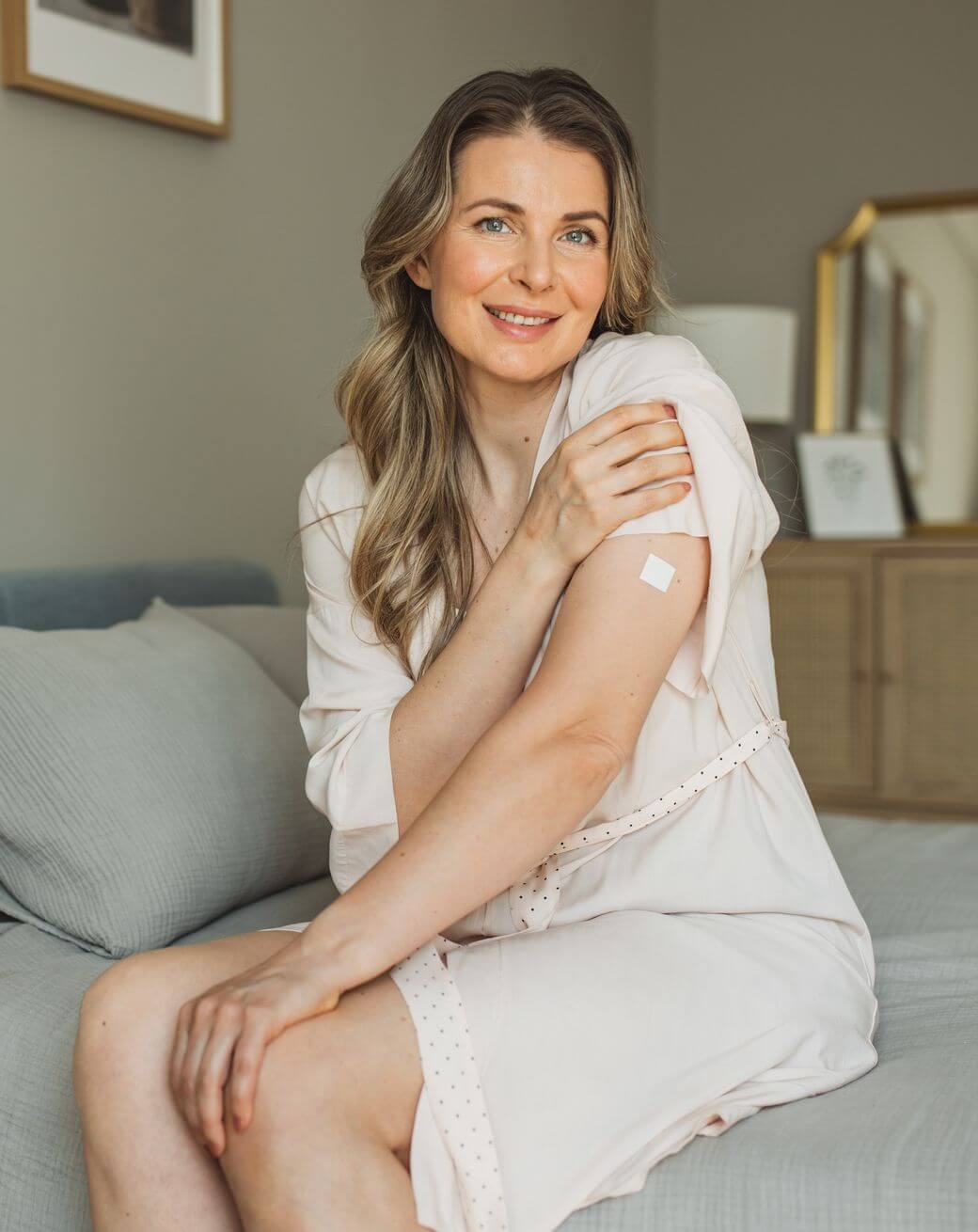 woman-sits-on-a-bed-in-a-white-robe