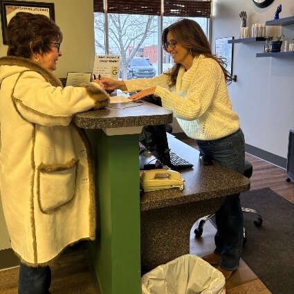 Female patient and receptionist going over paperwork