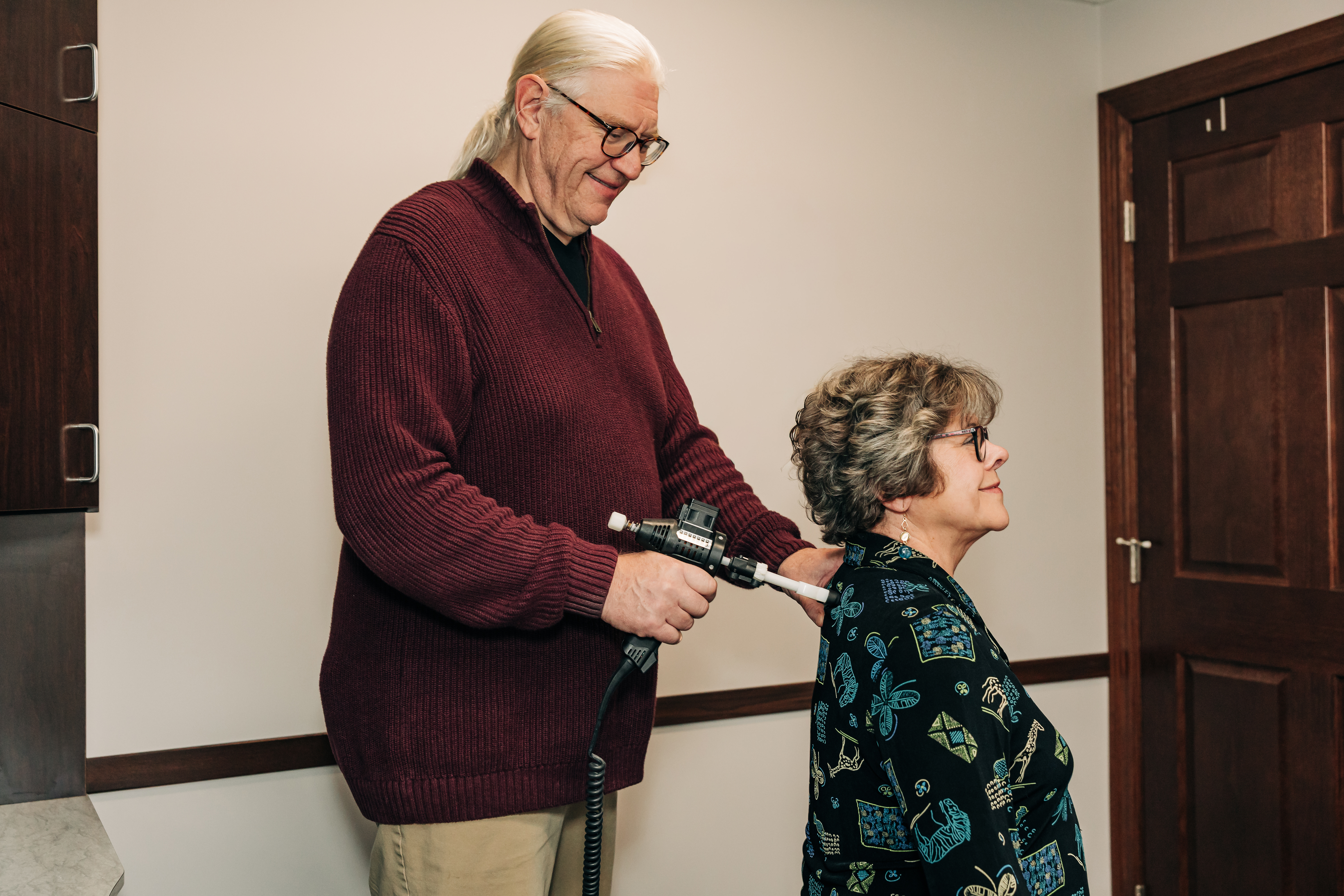 Chiropractor performing a gentle Arthrostim instrument adjustment on a patient in Grand Rapids, MN