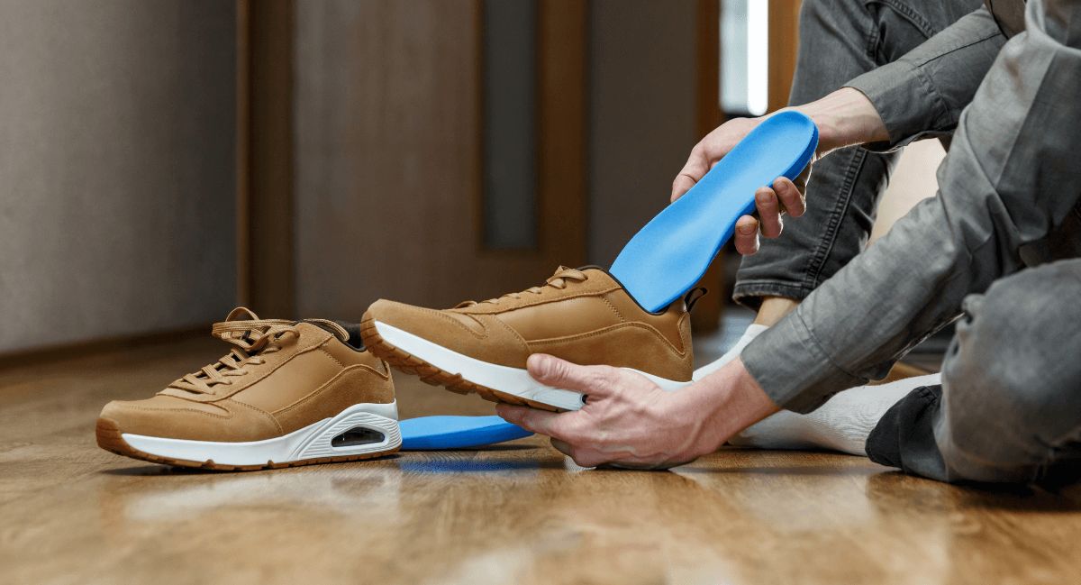 Man inserting Orthotics into shoes