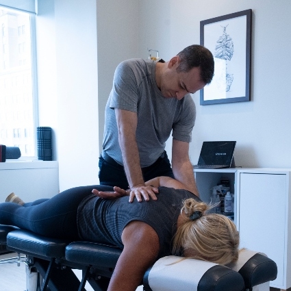 Dr Michael adjusting patients upper back