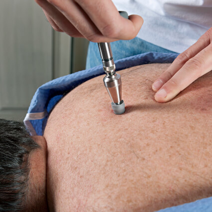 Chiropractor using activator technique to adjust patient