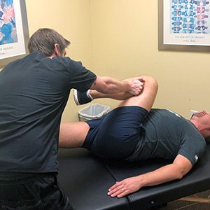 Massage therapist helping a patient stretch