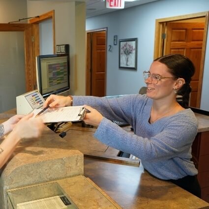staff handing patient forms