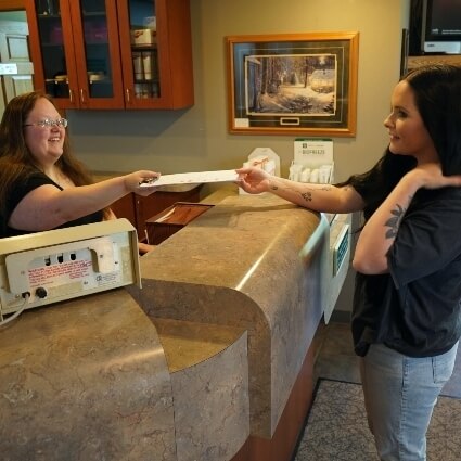staff handing patient paperwork