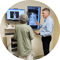 Dr. Erickson with senior patient pointing to xray