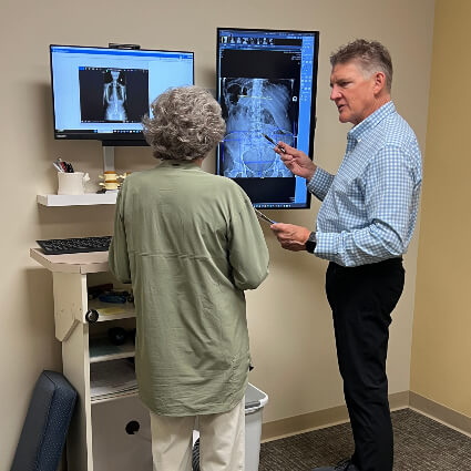 Erickson Clinic of Chiropractic Chiropractor Dr. Rick Looking at xray with patient