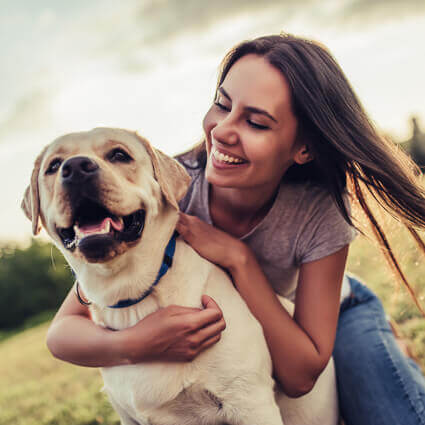 woman huging yellow lab