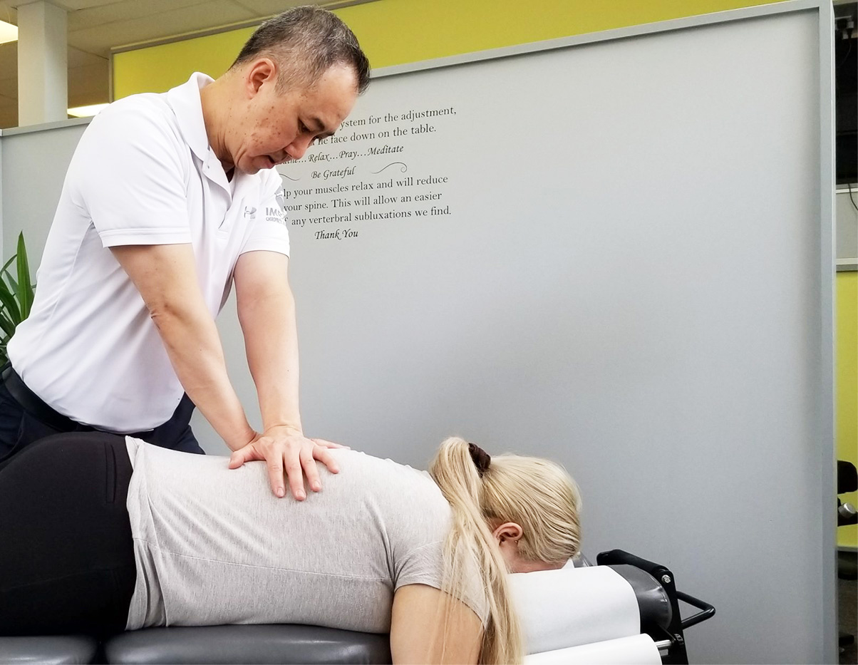 Doctor adjusting woman's back