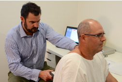 Dr Peter conducting a scan on a new patient to objectively determine how his spine is functioning