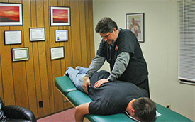 Warren chiropractor adjusts patient