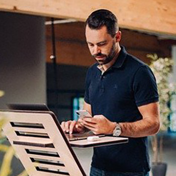 man standing at a desk and working